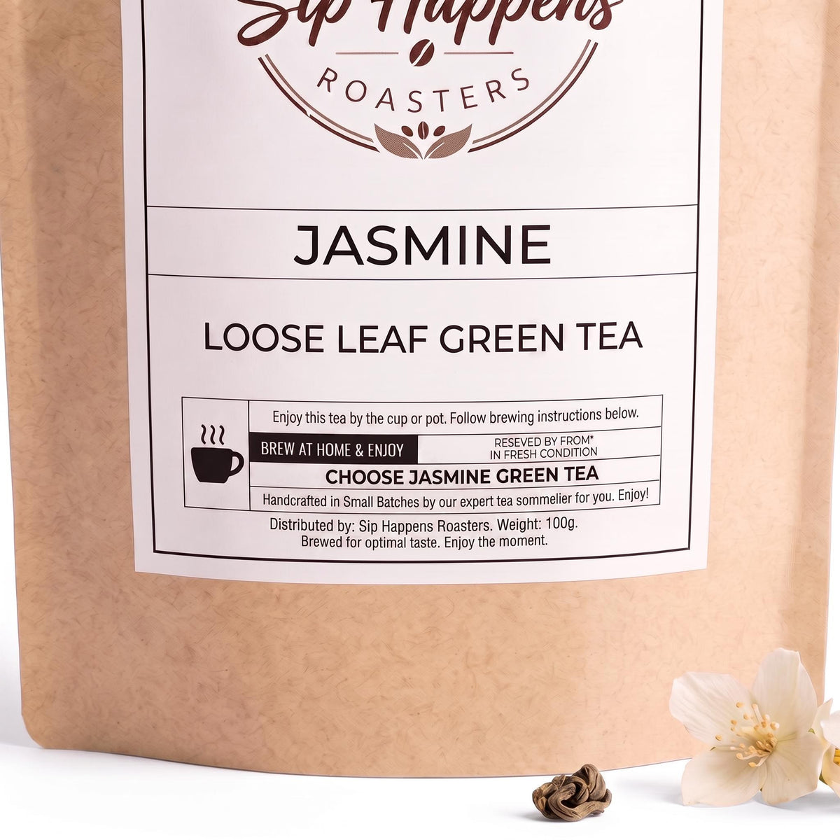 Pouch of Sip Happens Roasters Jasmine Loose Leaf Green Tea and a small white jasmine flower on a white surface.