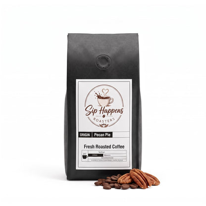 A black bag of Sip Happens Roasters Pecan Pie, standing on a white background with roasted coffee beans and pecans in front.